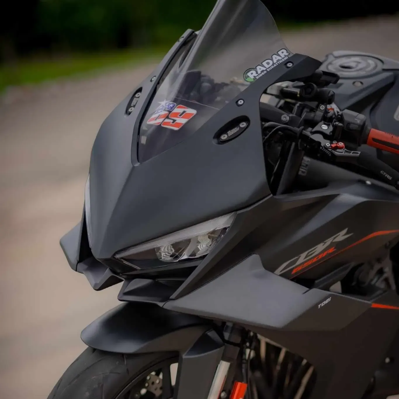 Rider beside a superbike fitted with carbon winglets